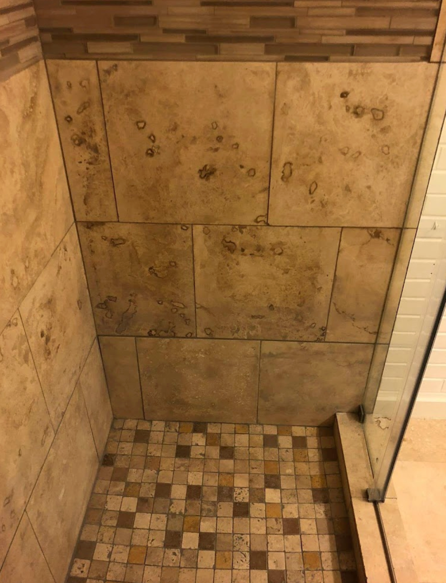 A shower stall with tiles on the wall and floor