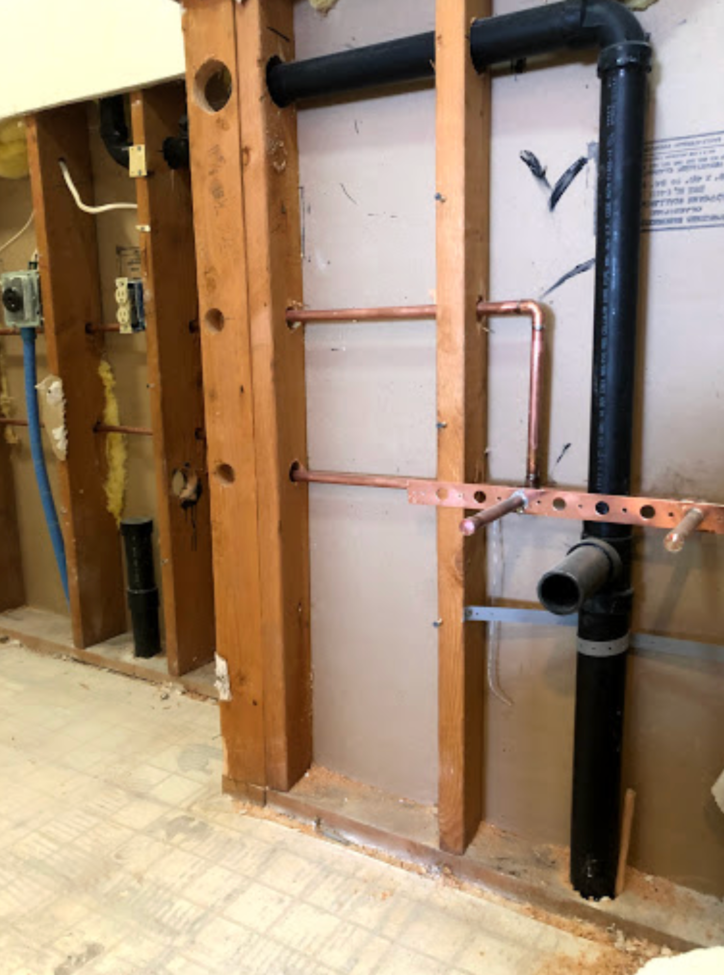 A bathroom with a lot of pipes coming out of the wall.