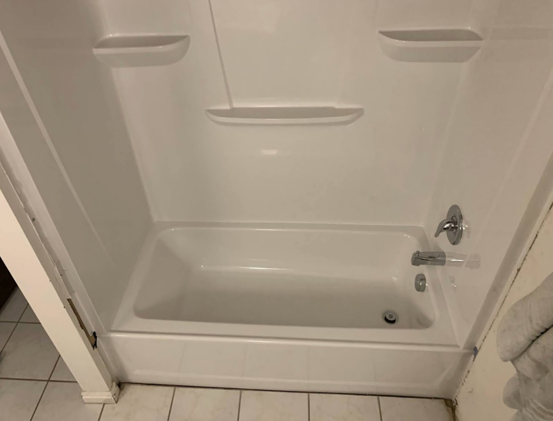 A white bathtub in a bathroom with a shower stall.