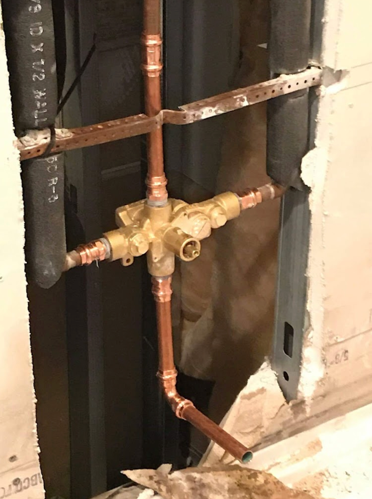 A close up of a copper pipe in a wall