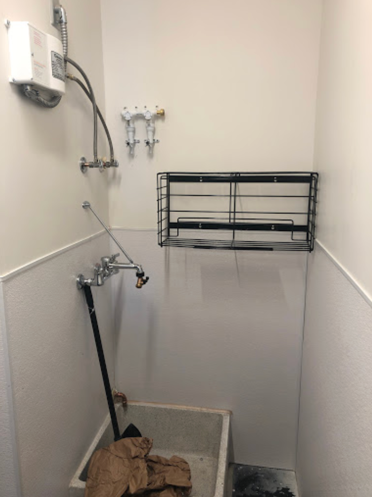 A bathroom with a sink and a shelf on the wall