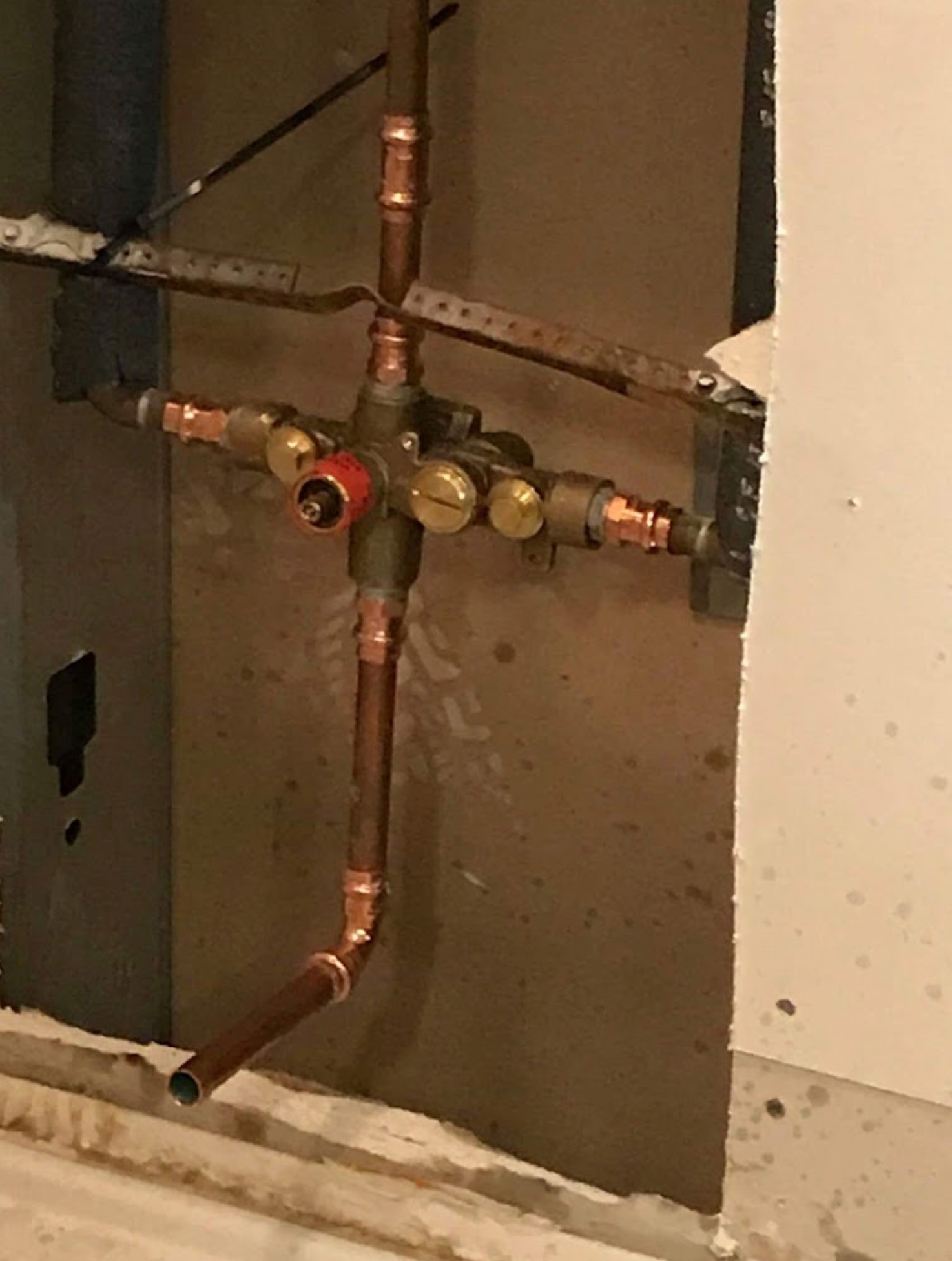 A close up of a copper pipe on a wall.