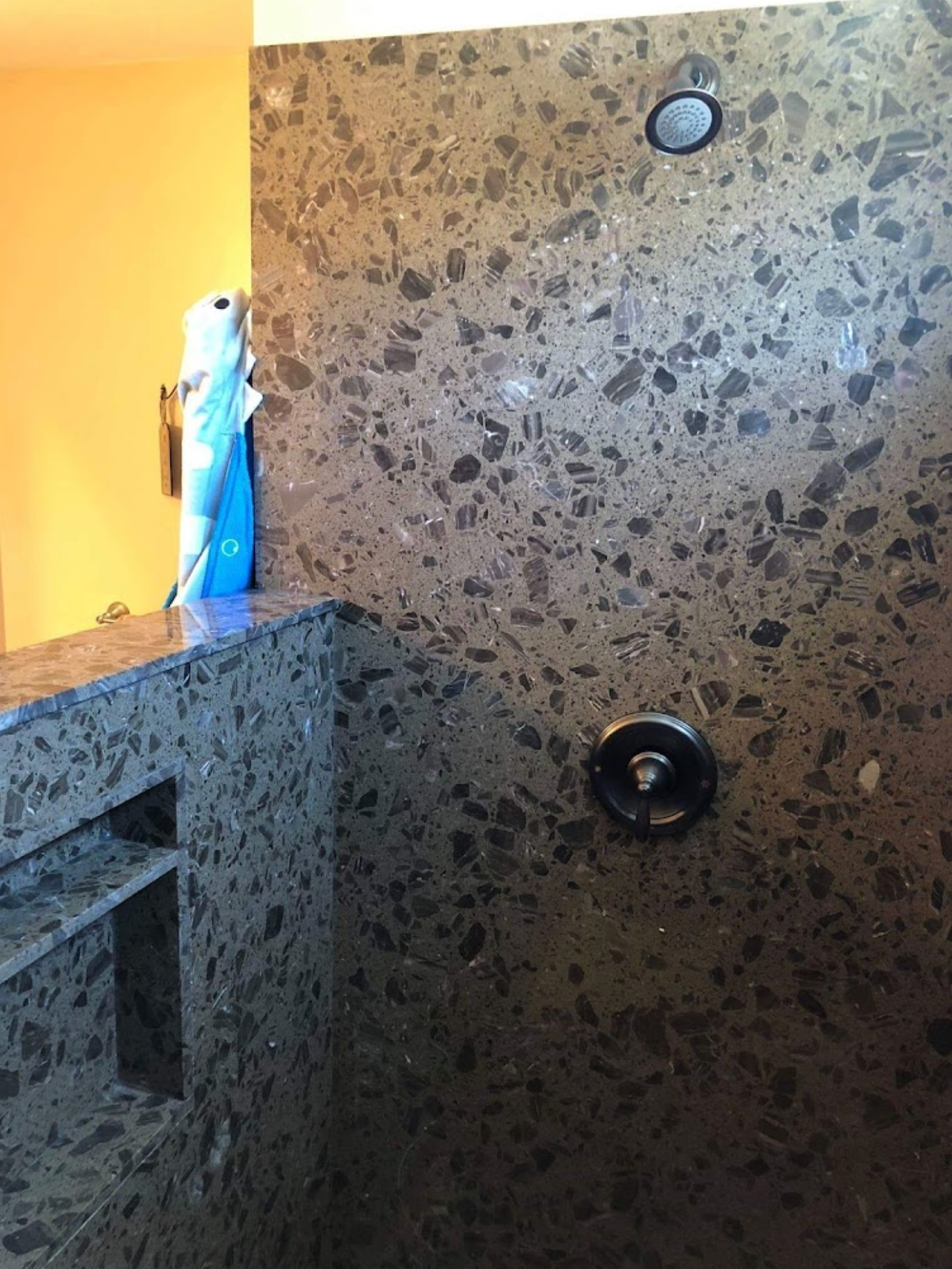 A bathroom with a shower and a towel hanging on the wall