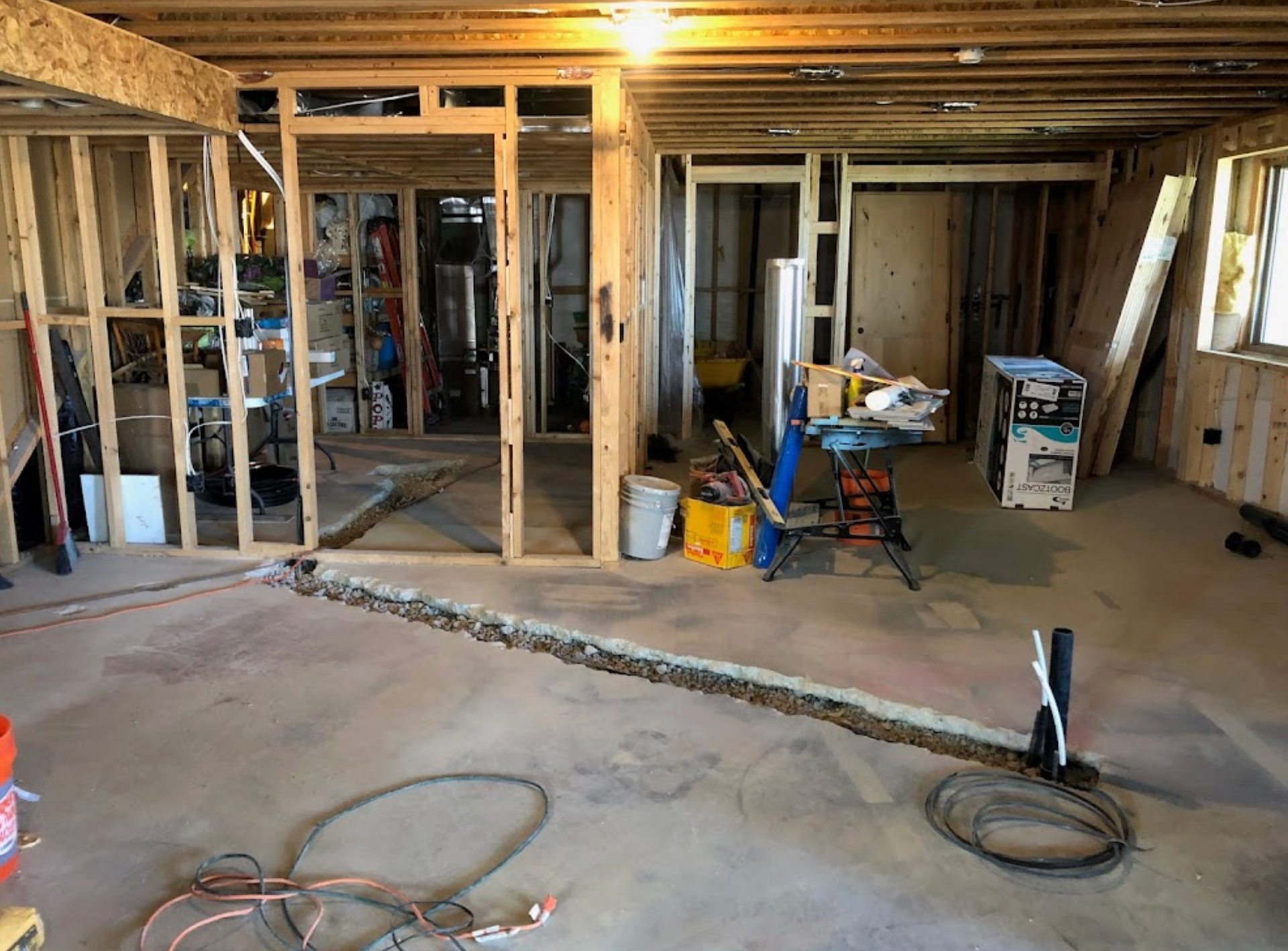 A room under construction with a lot of wires on the floor.