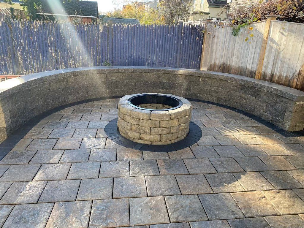 A fire pit is sitting in the middle of a brick patio.