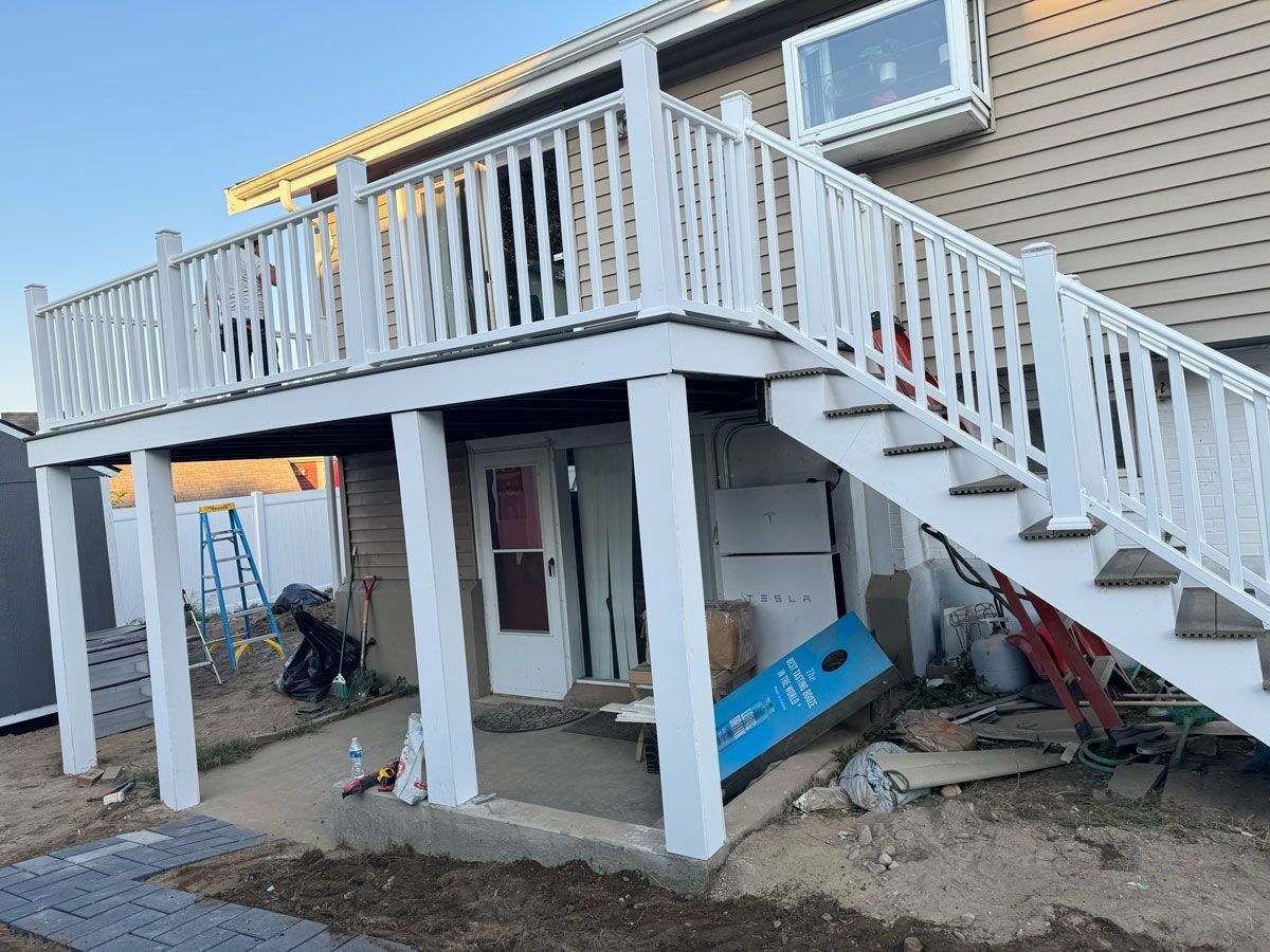 A deck with stairs leading up to it is being built on the side of a house.