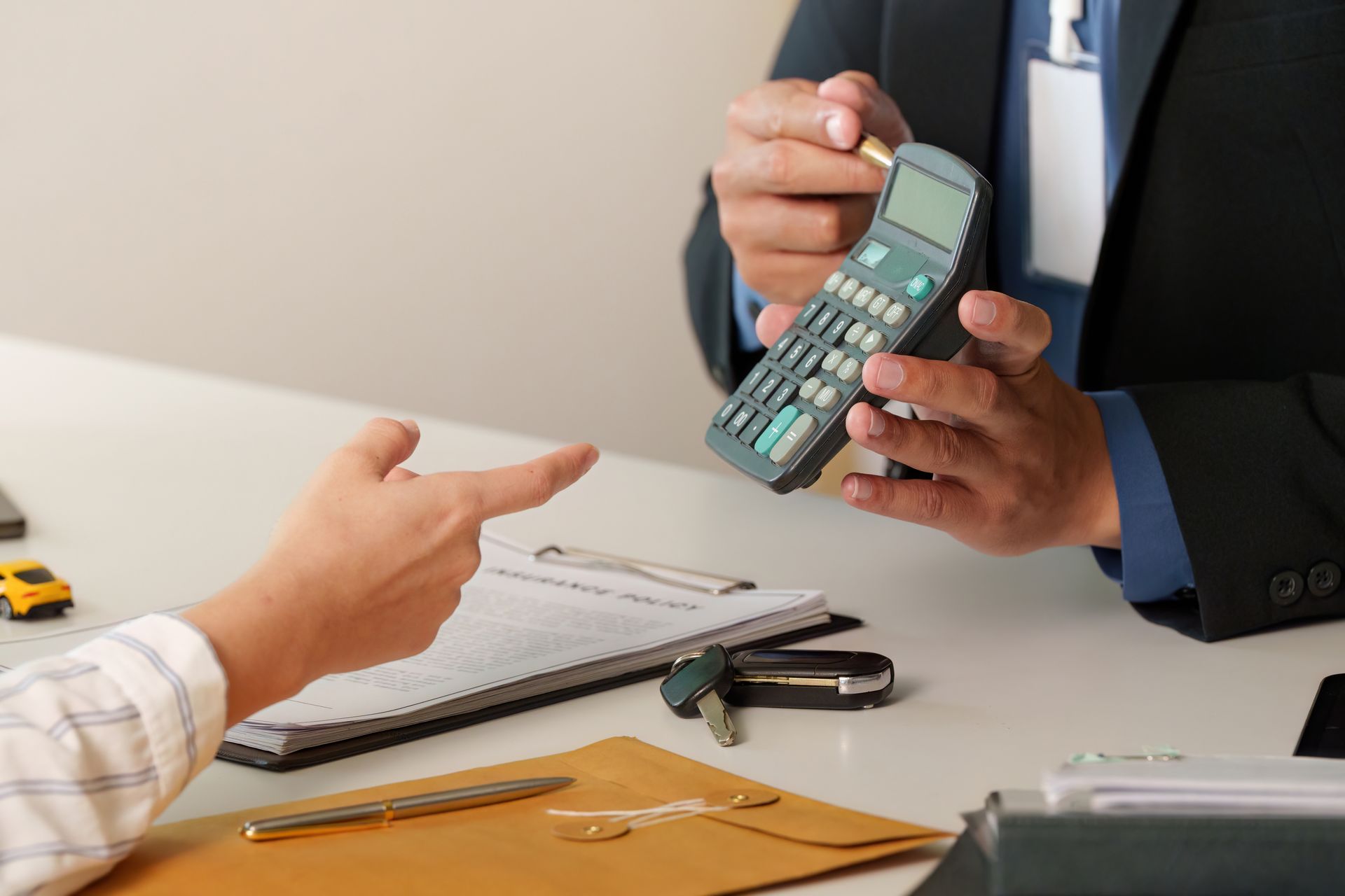 Woman with afro smiles, wearing black polka dot dress, sitting in sunlit room.