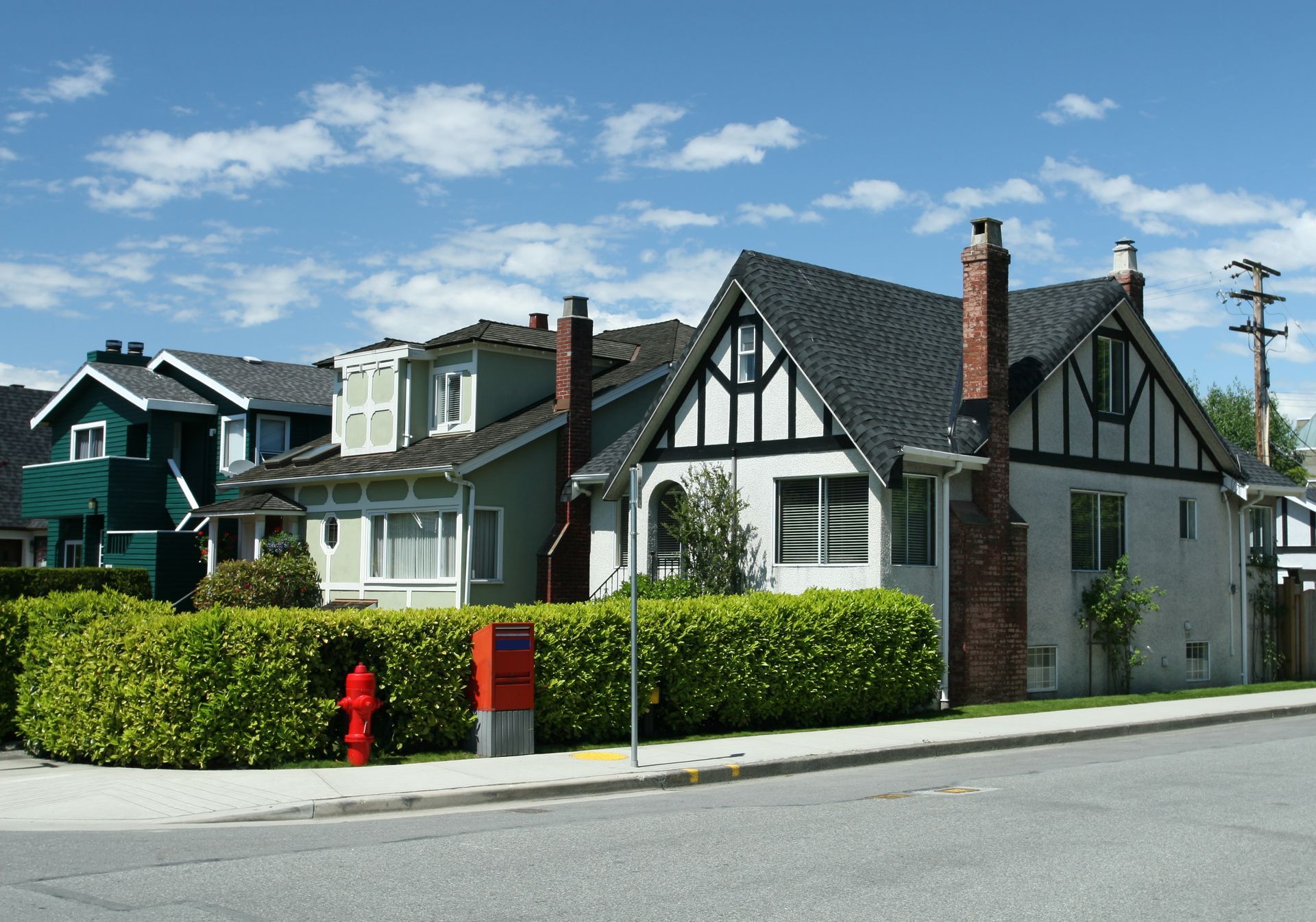 Two people seated at a table, smiling, as another person holds up keys, documents on the table.
