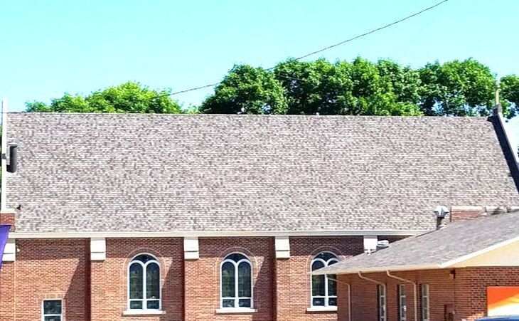 A brick building with a roof that is covered in shingles