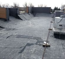 The roof of a building with a broken roof and a few boxes on it.