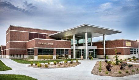 A large brick building with a covered entrance and a walkway leading to it.