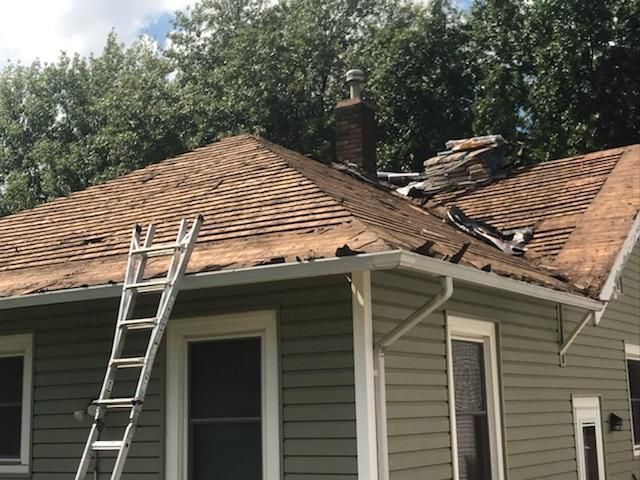 A ladder is sitting on the roof of a house.