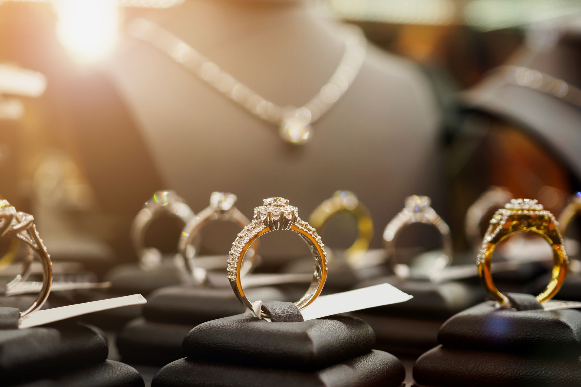 Jewelry, diamond rings, and necklaces are shown in a luxury retail store