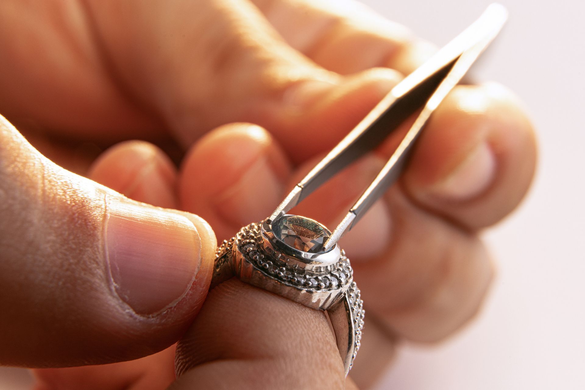 A jeweler's hands expertly repairing a ring in a close-up workshop scene A jeweler's hands expertly repairing a ring in a close-up workshop scene