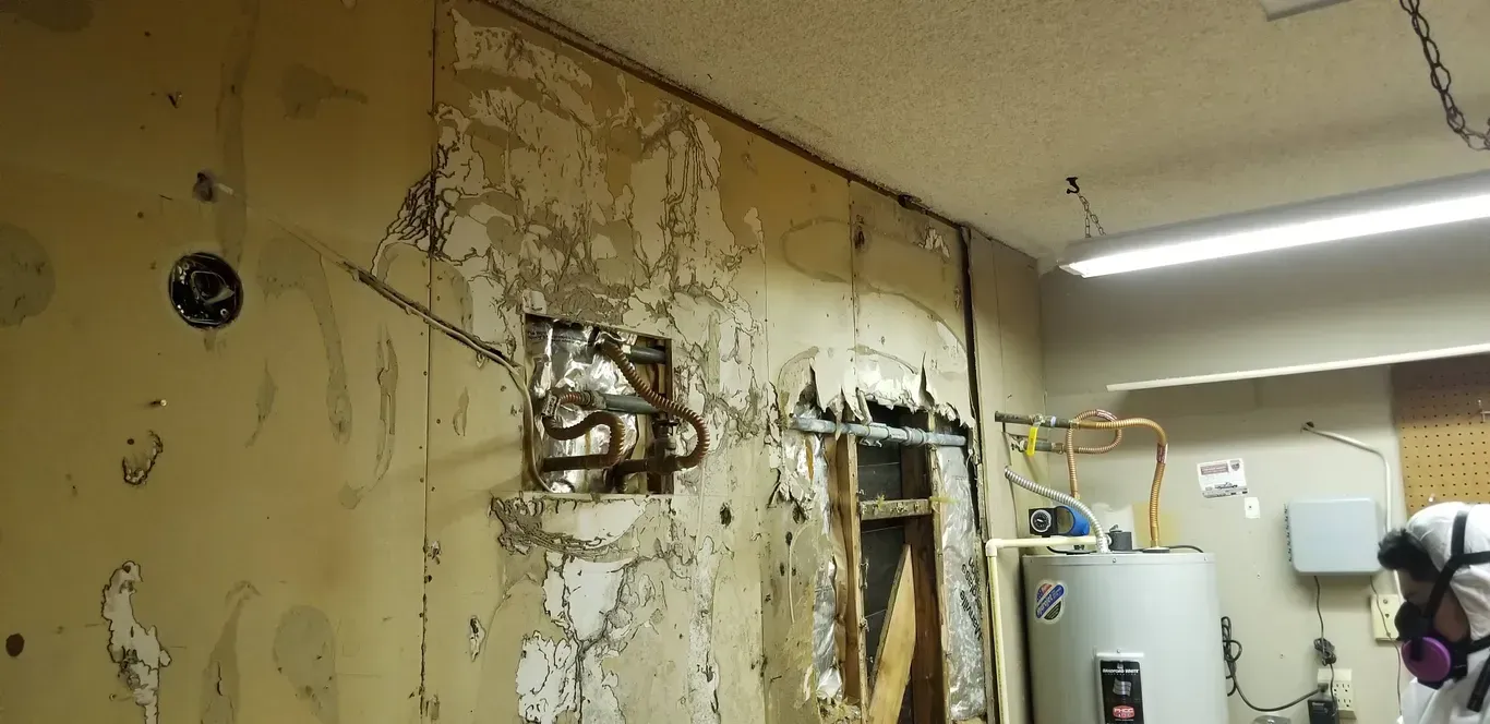 A room with a water heater and a wall that is being remodeled.