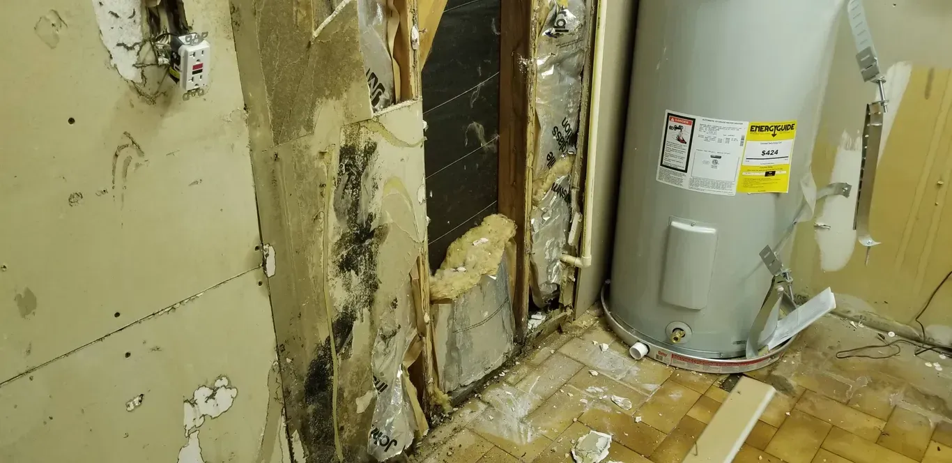 A water heater is sitting next to a wall in a room.