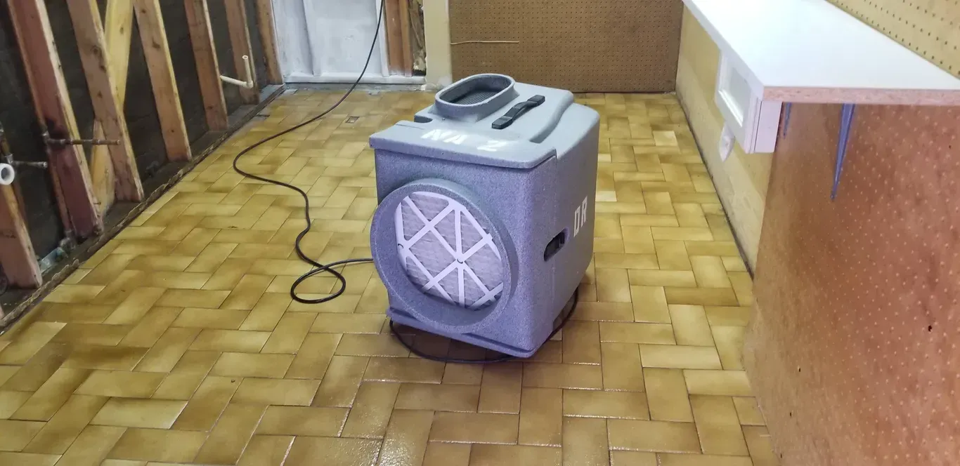 A gray box is sitting on a tiled floor in a room.