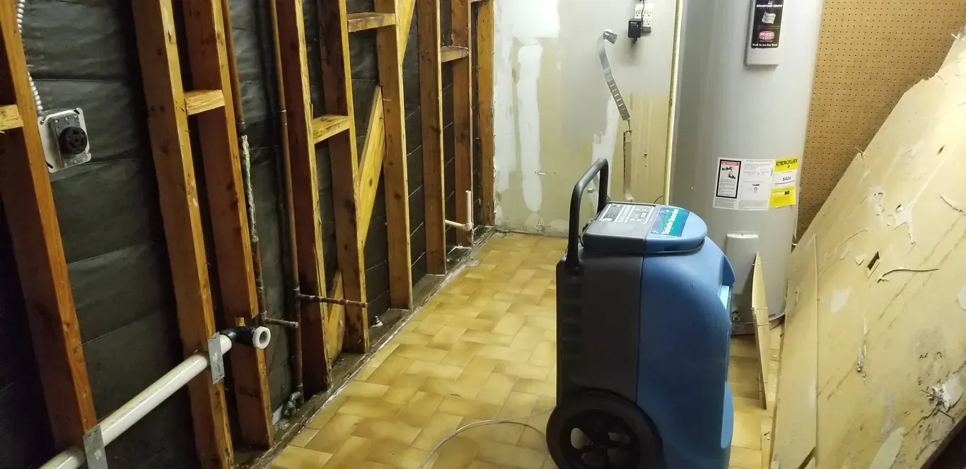 A room with a water heater and a vacuum cleaner in it.