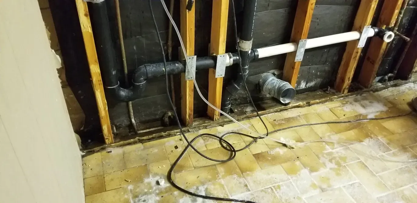 A room with a lot of pipes and wires on the floor.