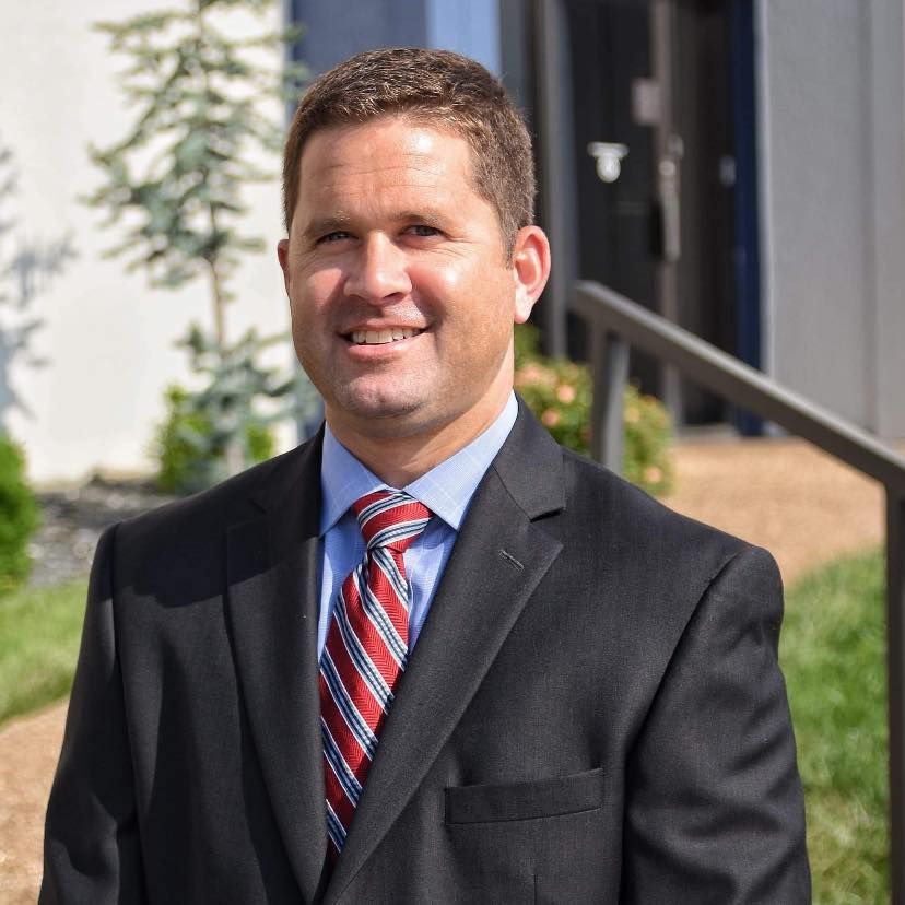 A man in a suit and tie is smiling for the camera.