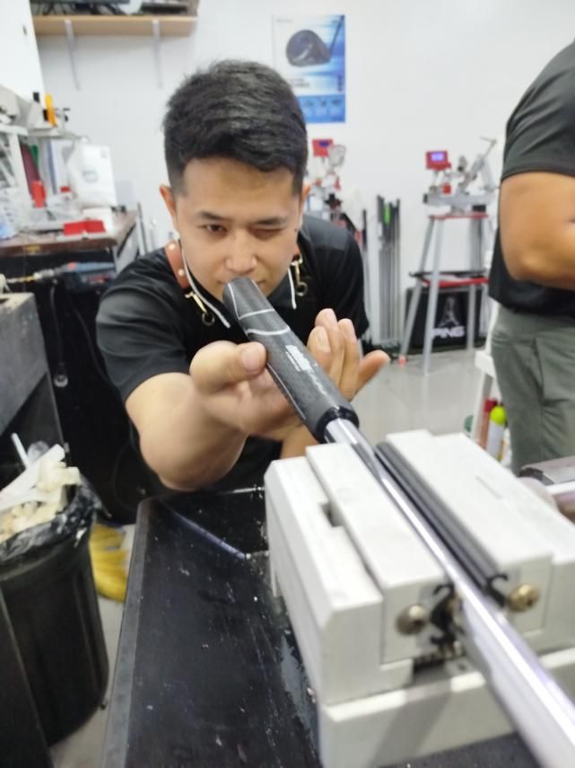 A man in a black shirt is working on a piece of equipment