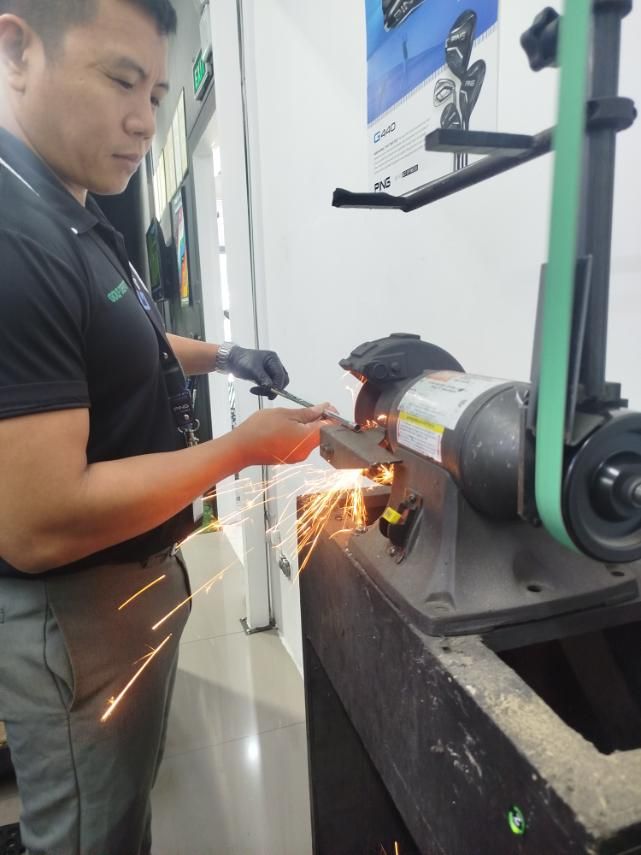 Man grinding metal with sparks flying in a workshop setting.