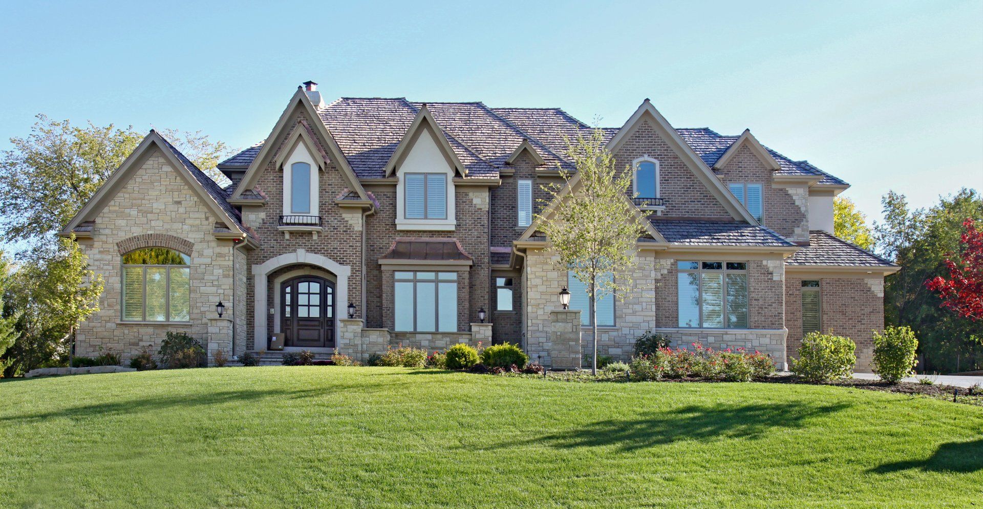 A large house with a lush green lawn in front of it.