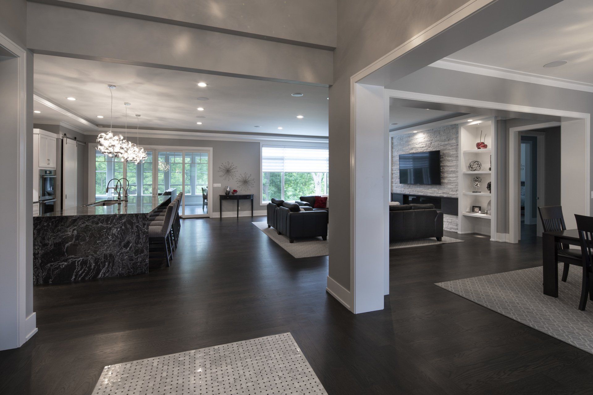 A living room , dining room , and kitchen in a large house.