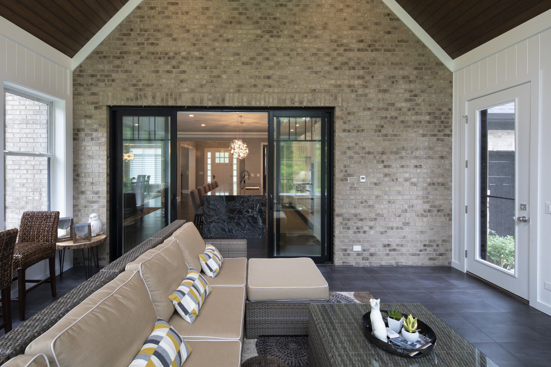 A living room with a couch , table , chairs and sliding glass doors.