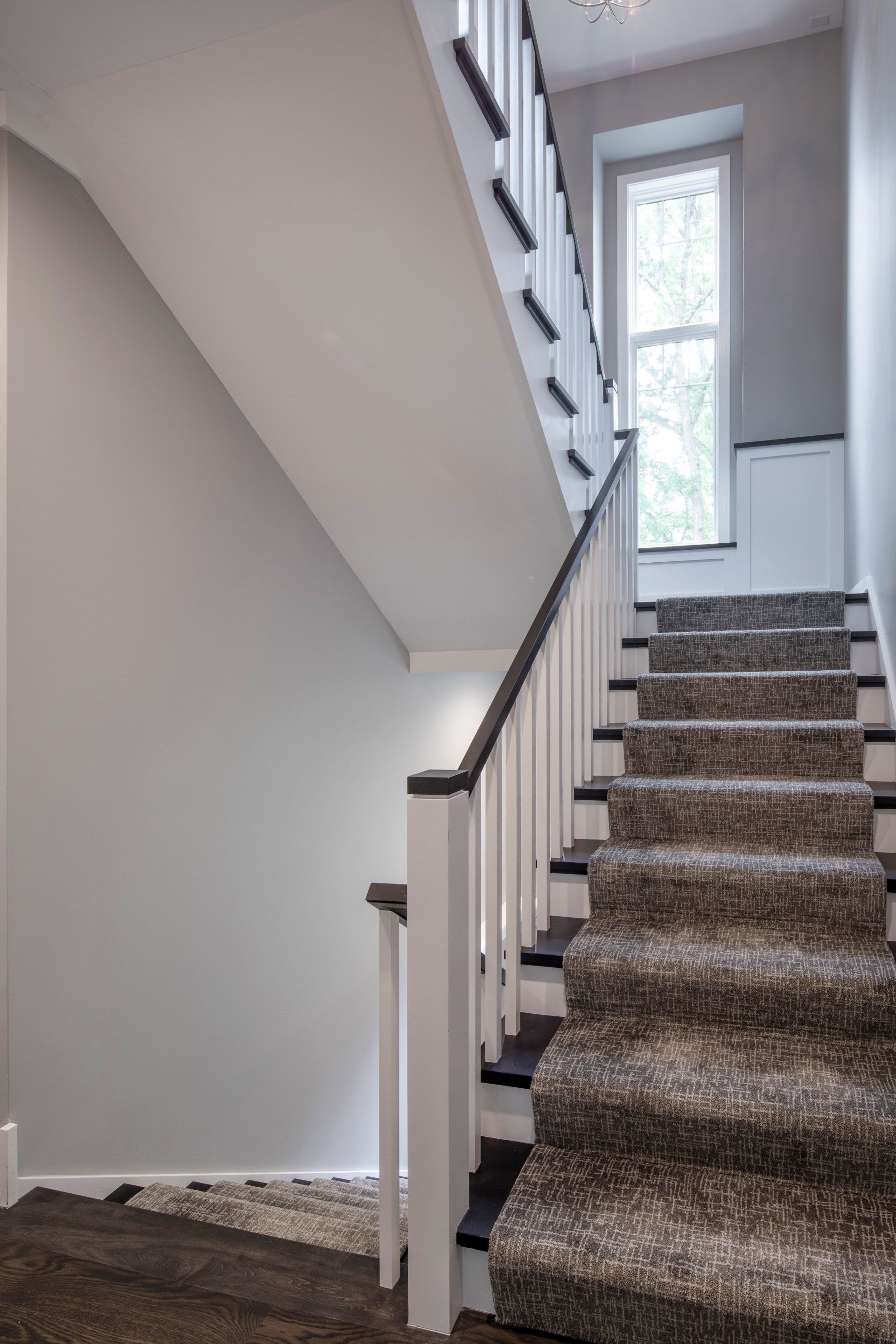 A staircase with a carpeted staircase leading up to the second floor of a house.