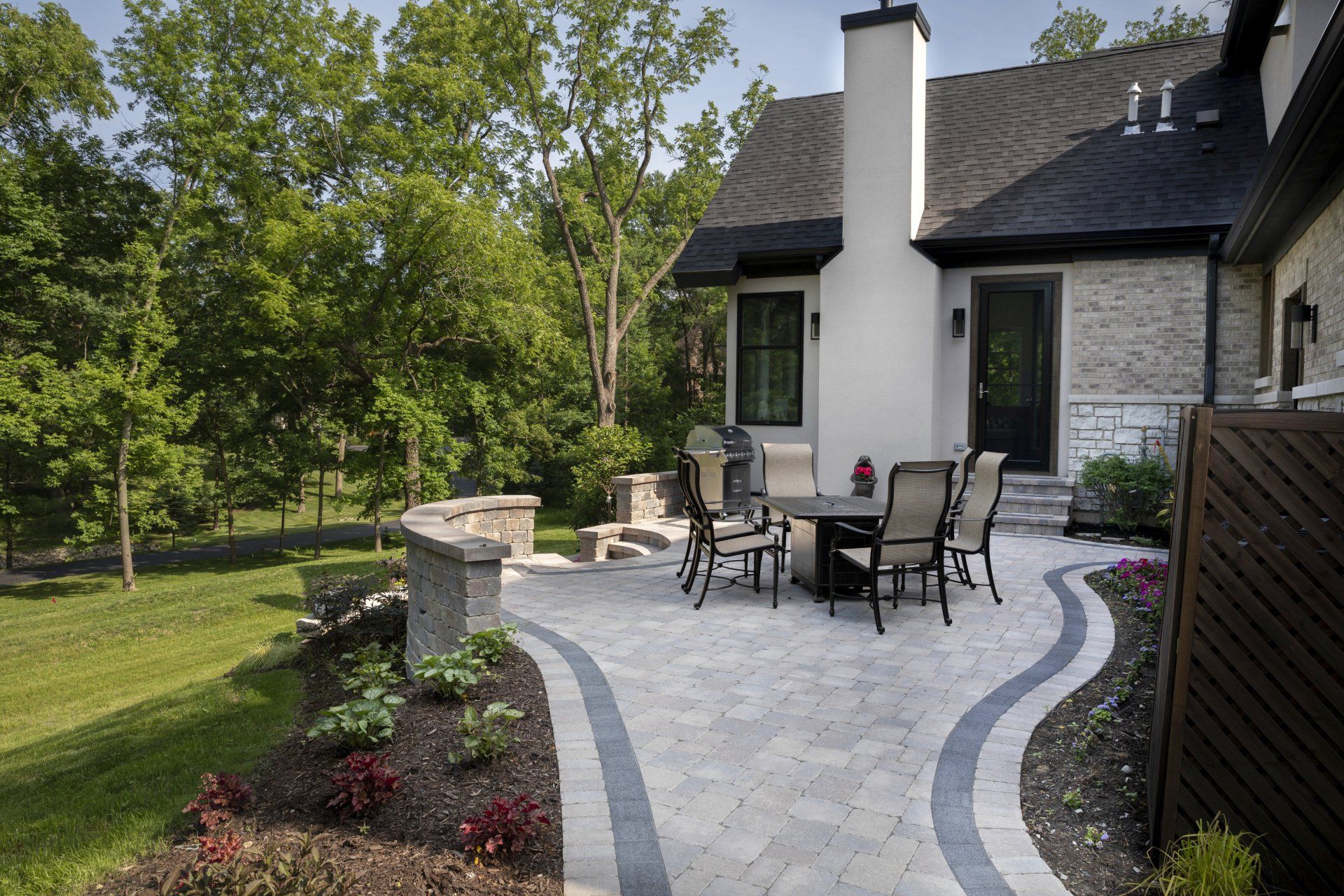 A patio with a table and chairs in front of a house