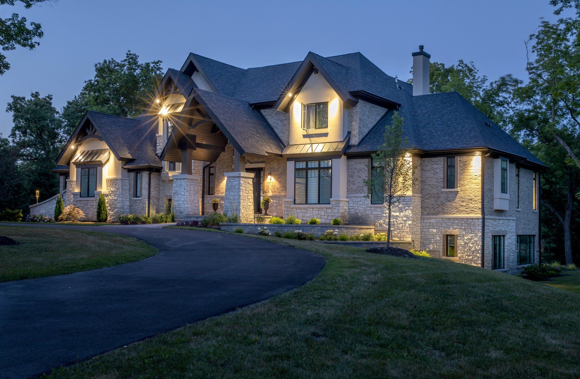 A large house with a lot of windows is lit up at night.