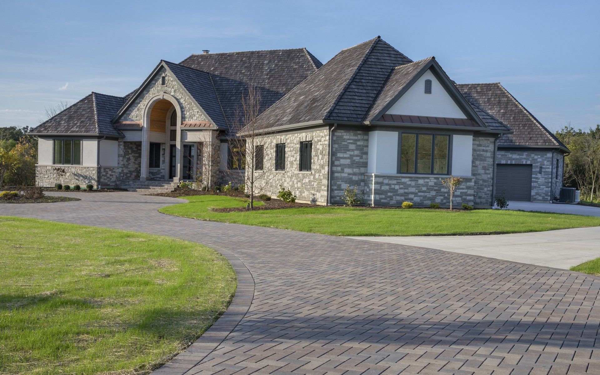 A large house with a brick driveway leading to it