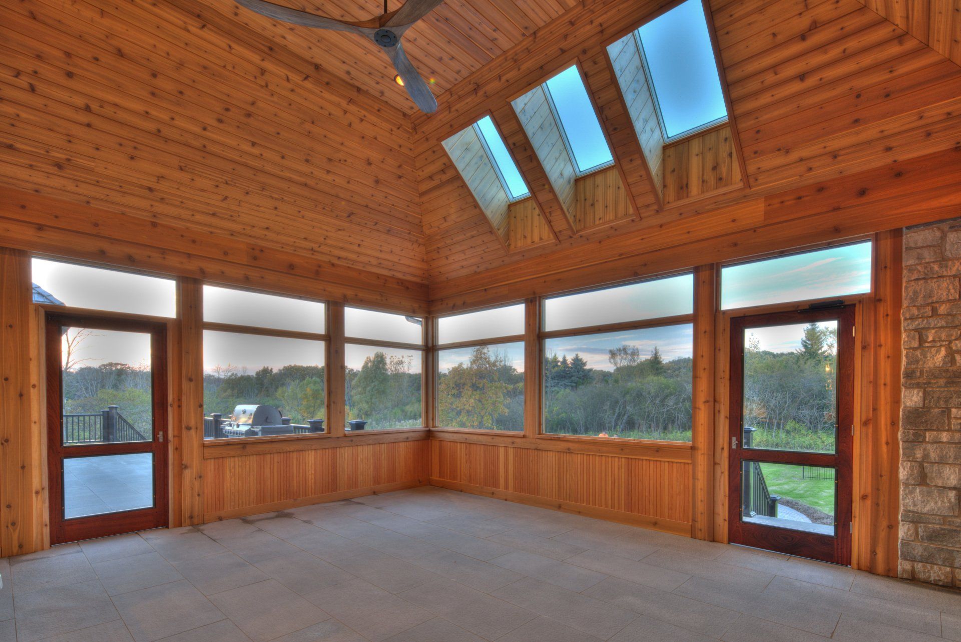 A room with a lot of windows and a ceiling fan
