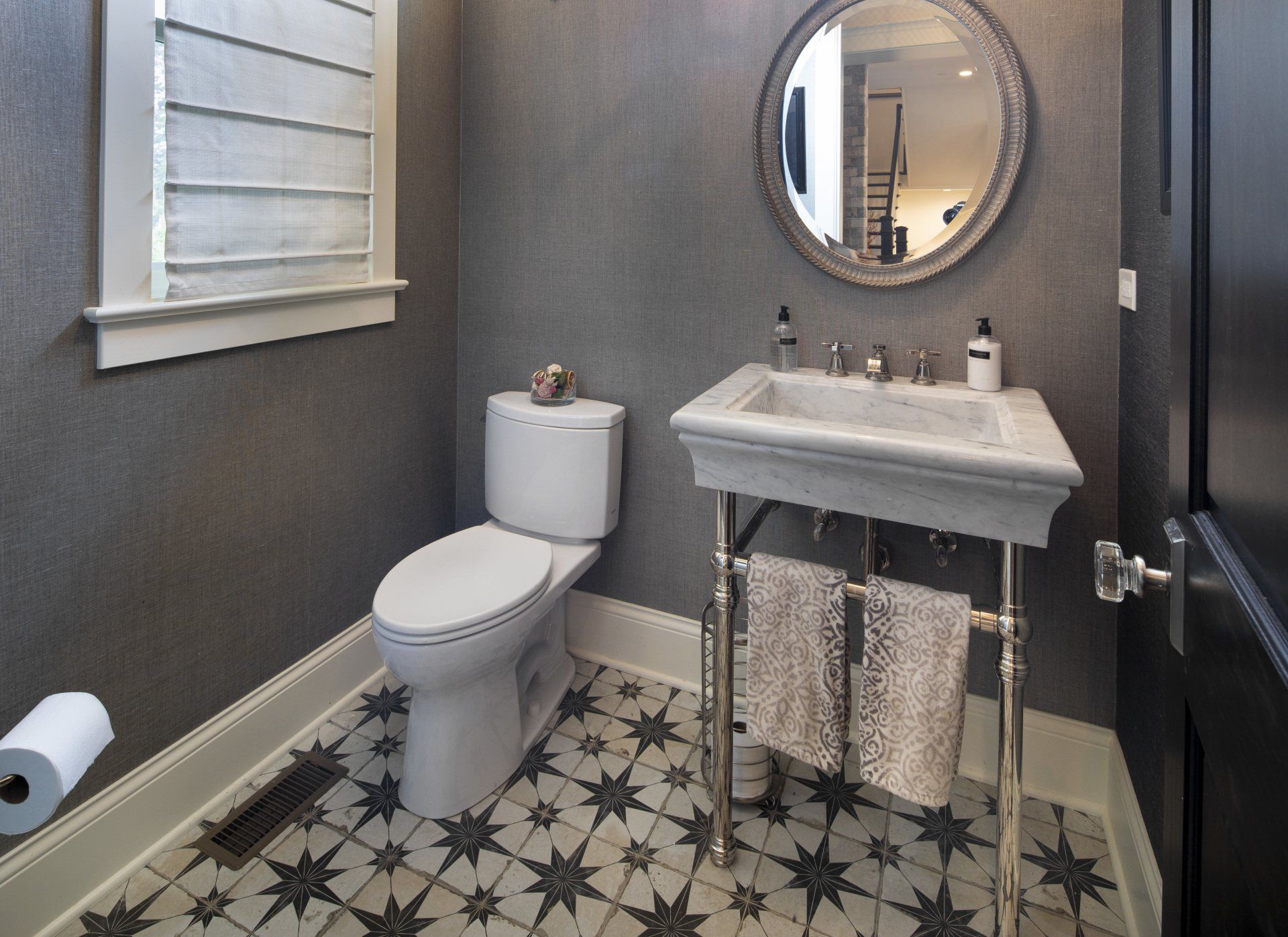 A bathroom with a toilet , sink and mirror