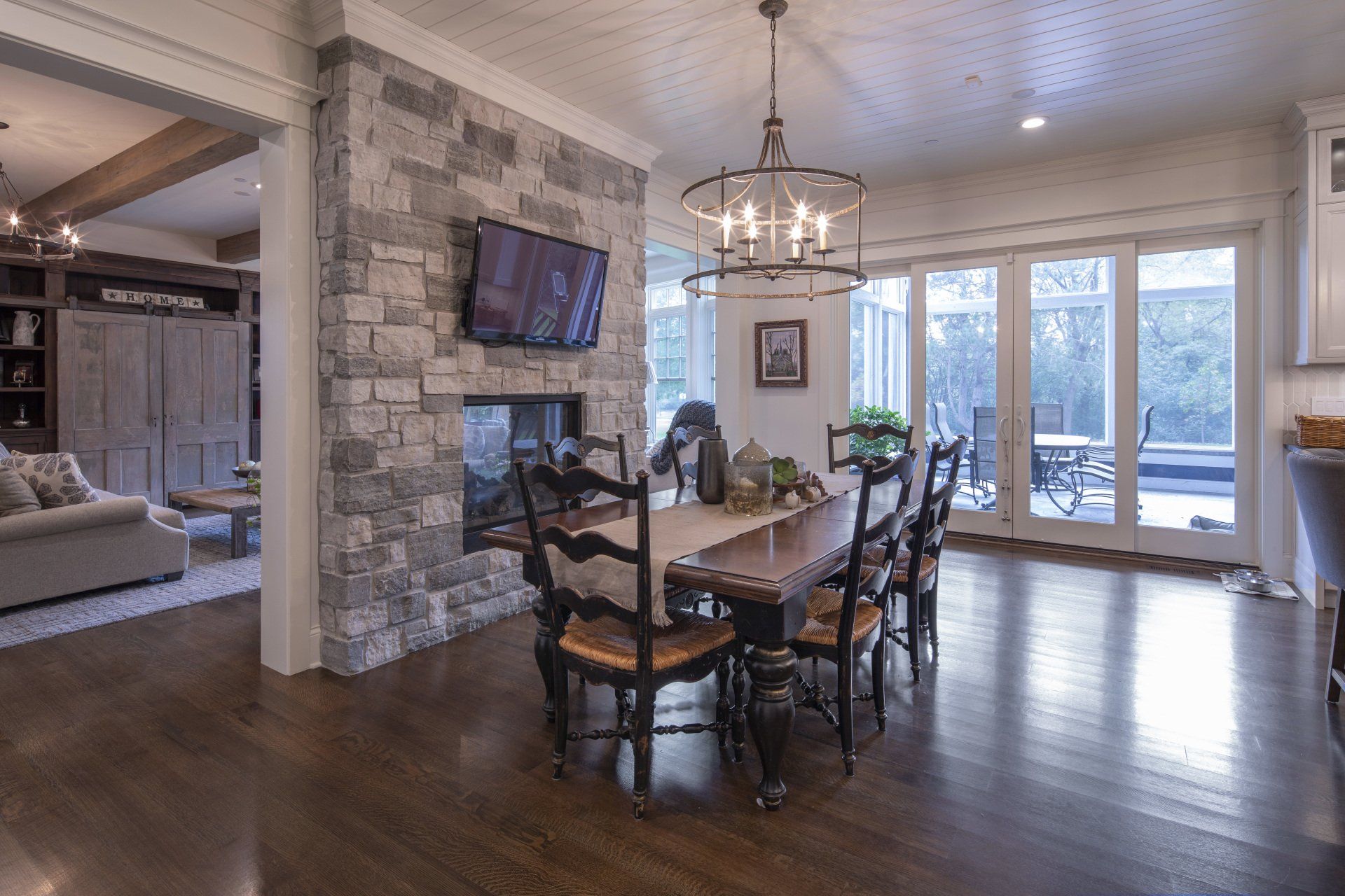 A dining room with a wooden table and chairs and a fireplace.