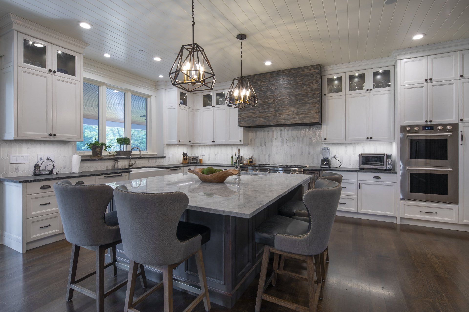 A large kitchen with white cabinets and a large island.