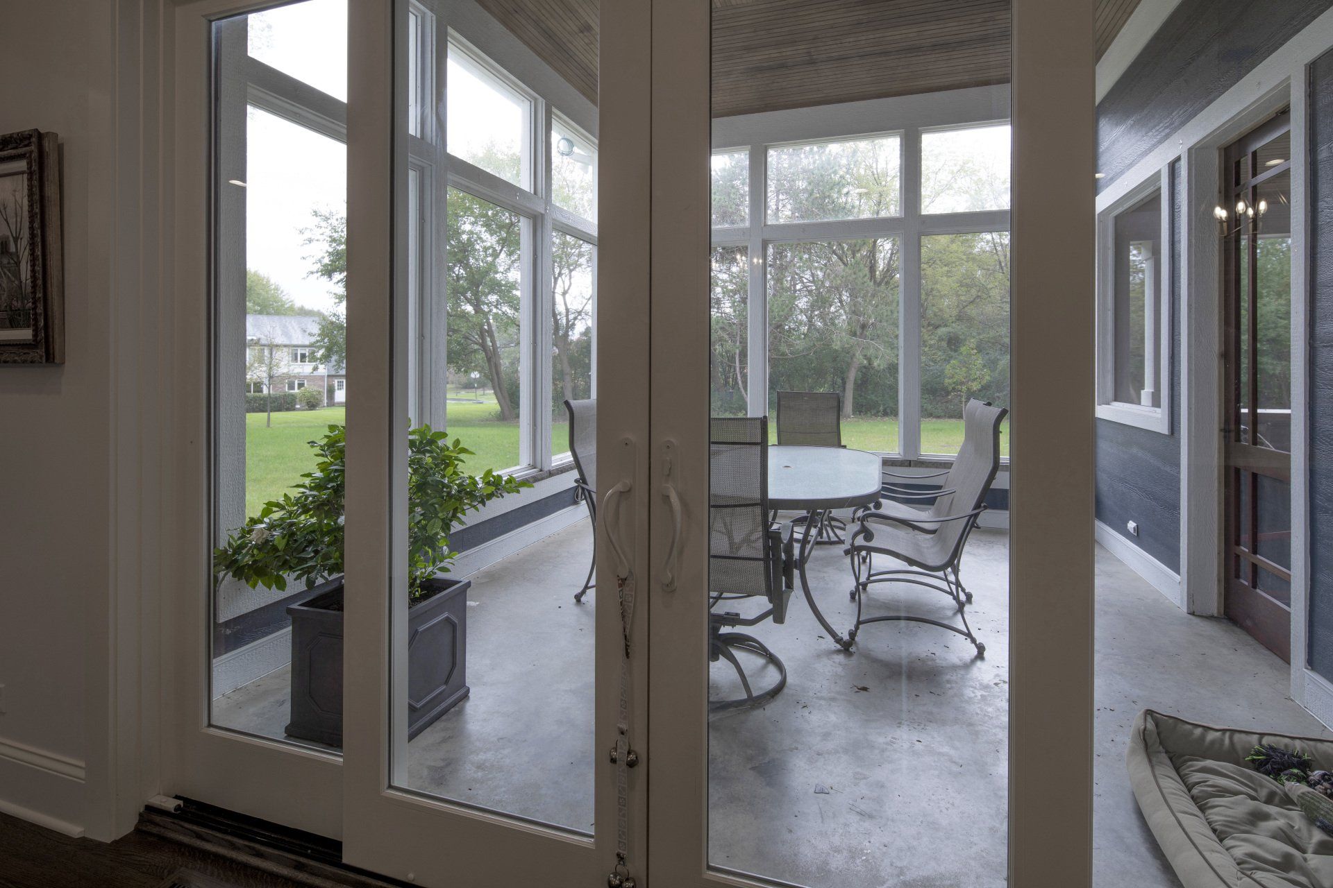 A sun room with sliding glass doors and a table and chairs.