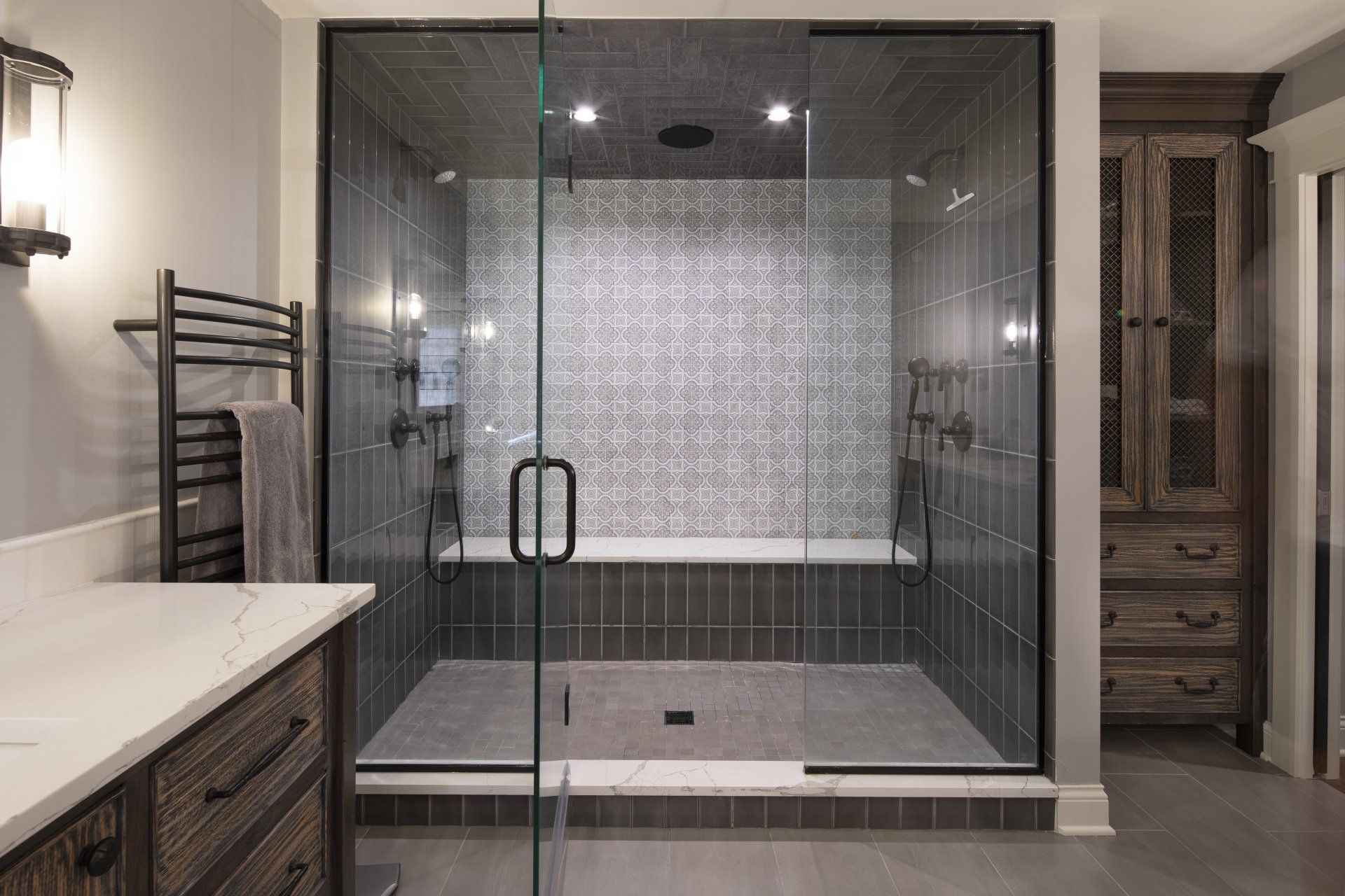A bathroom with a walk in shower and a glass door.