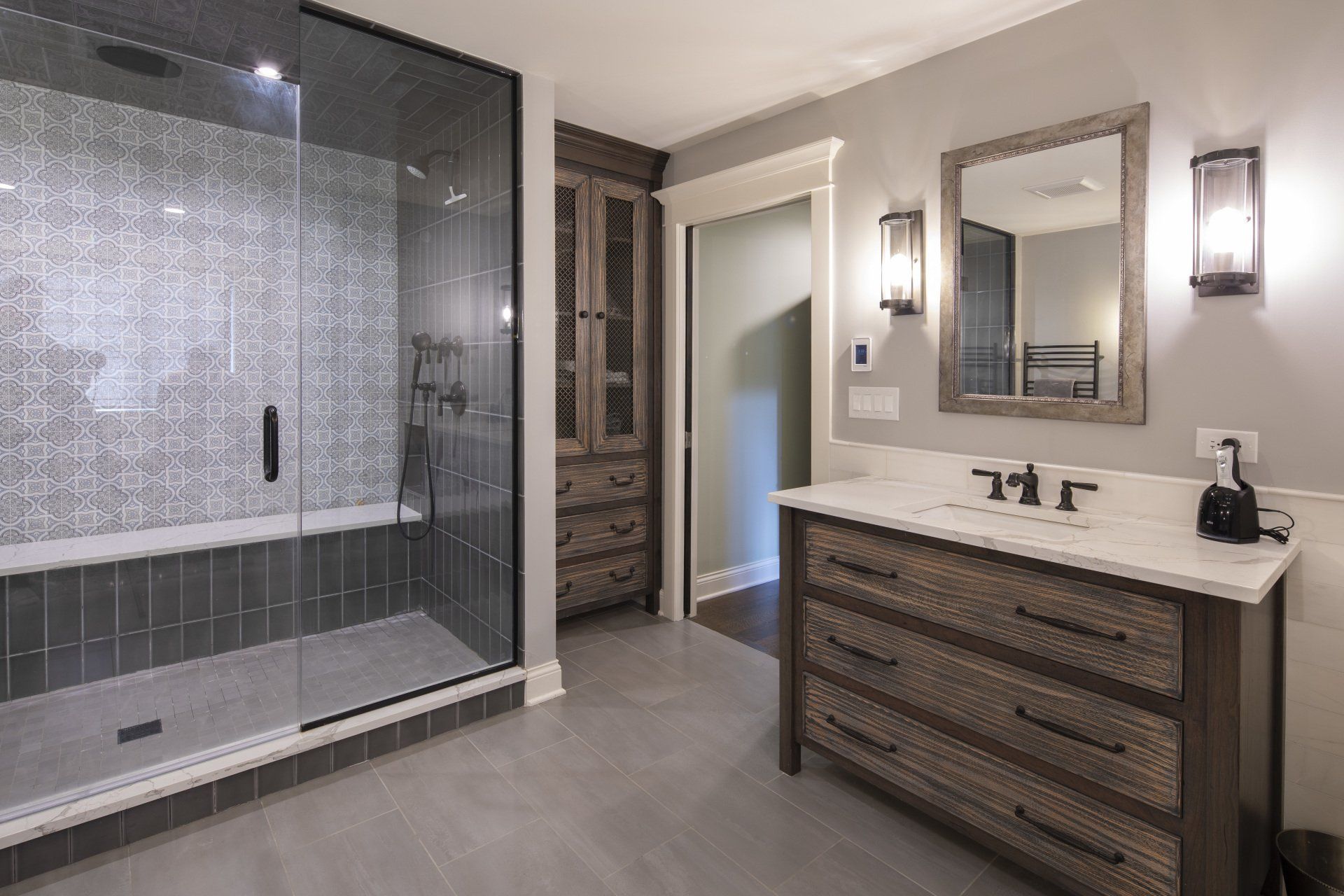 A bathroom with a walk in shower , sink and mirror.