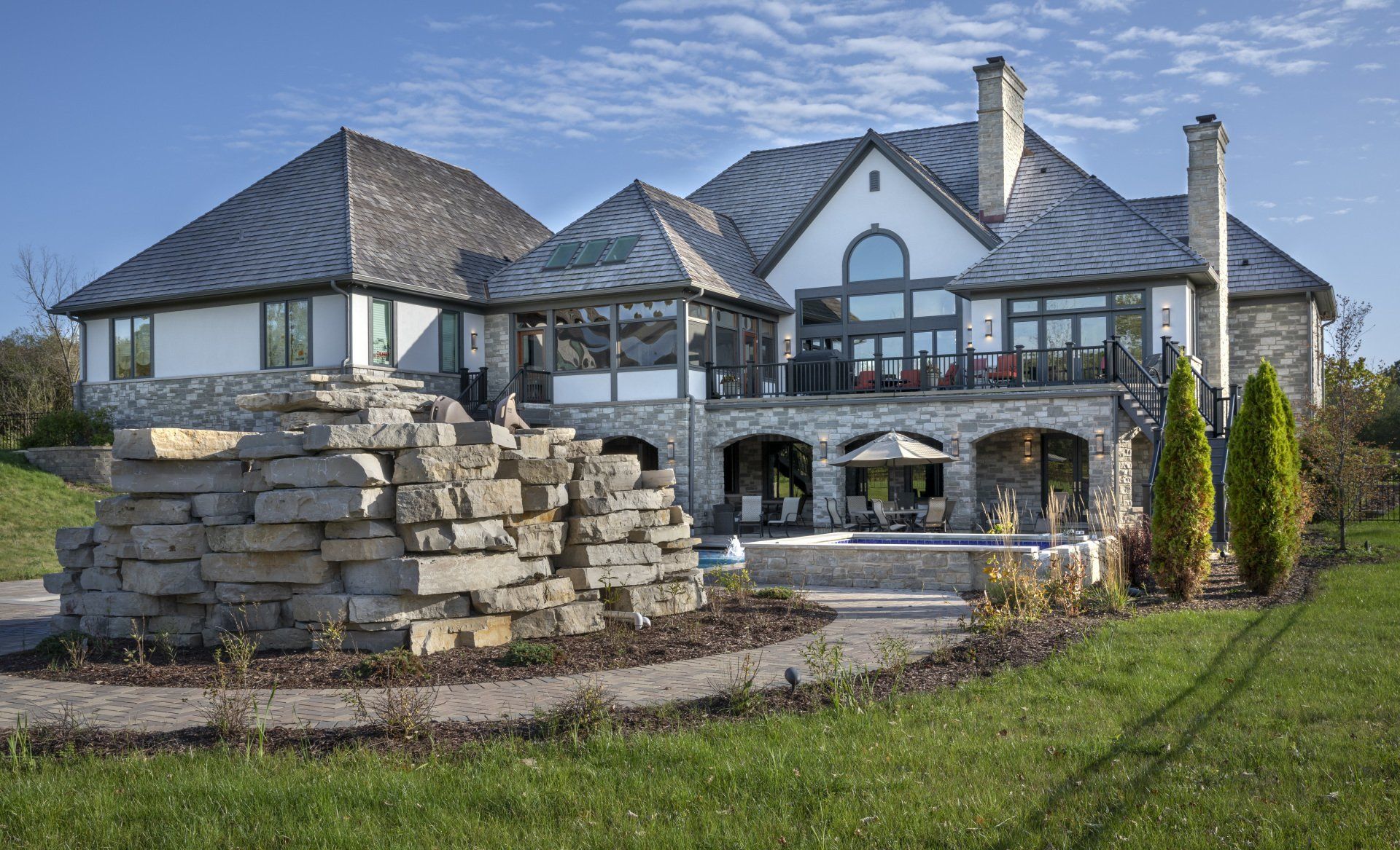 A large house with a large stone wall in front of it
