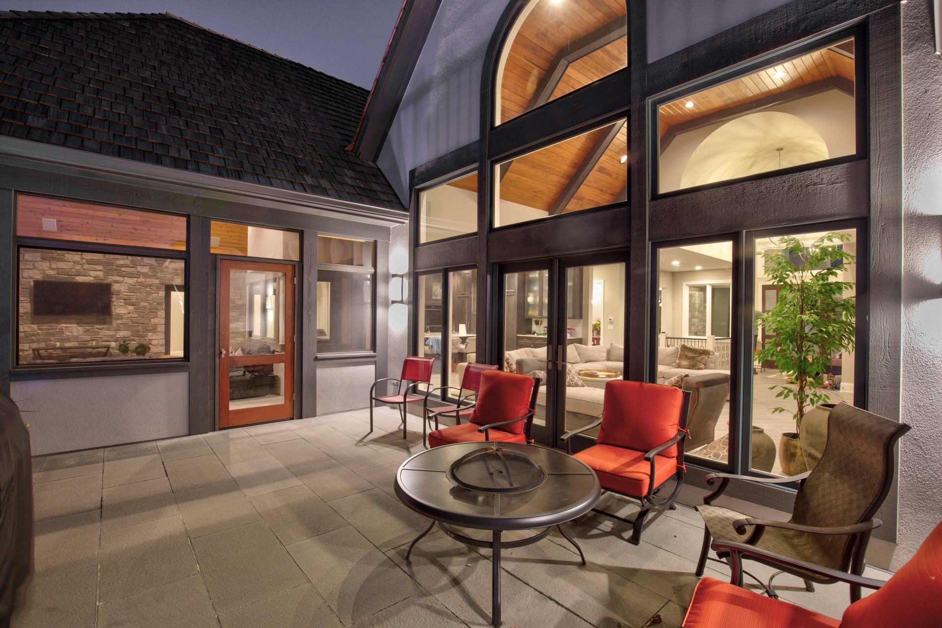 A patio with a table and chairs in front of a house.