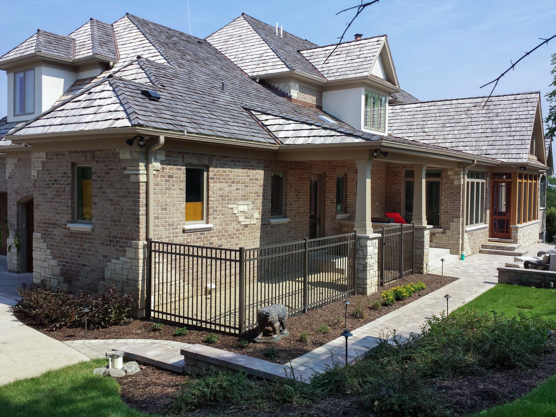A large brick house with a fence in front of it