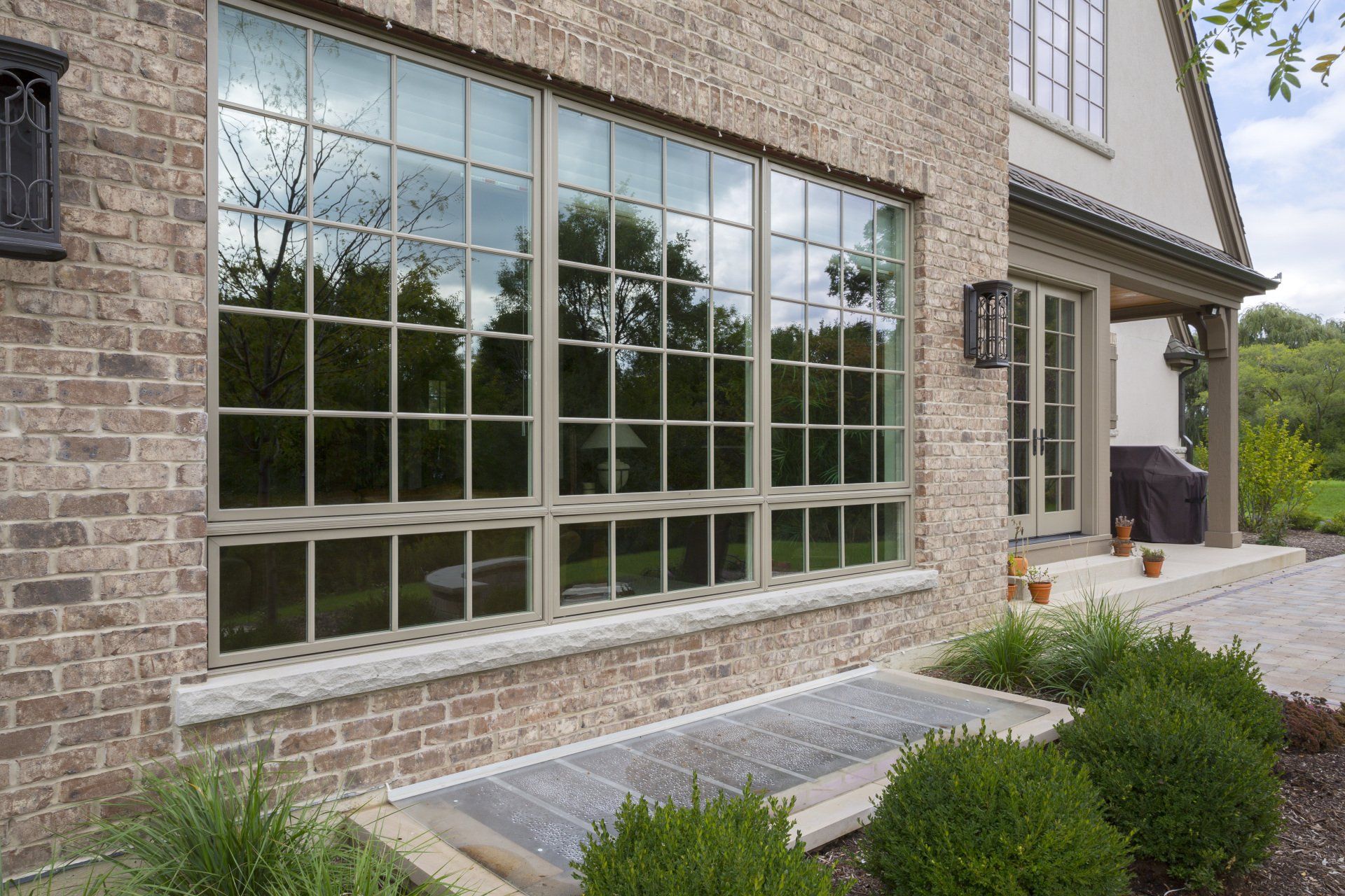 A large window on the side of a brick house.