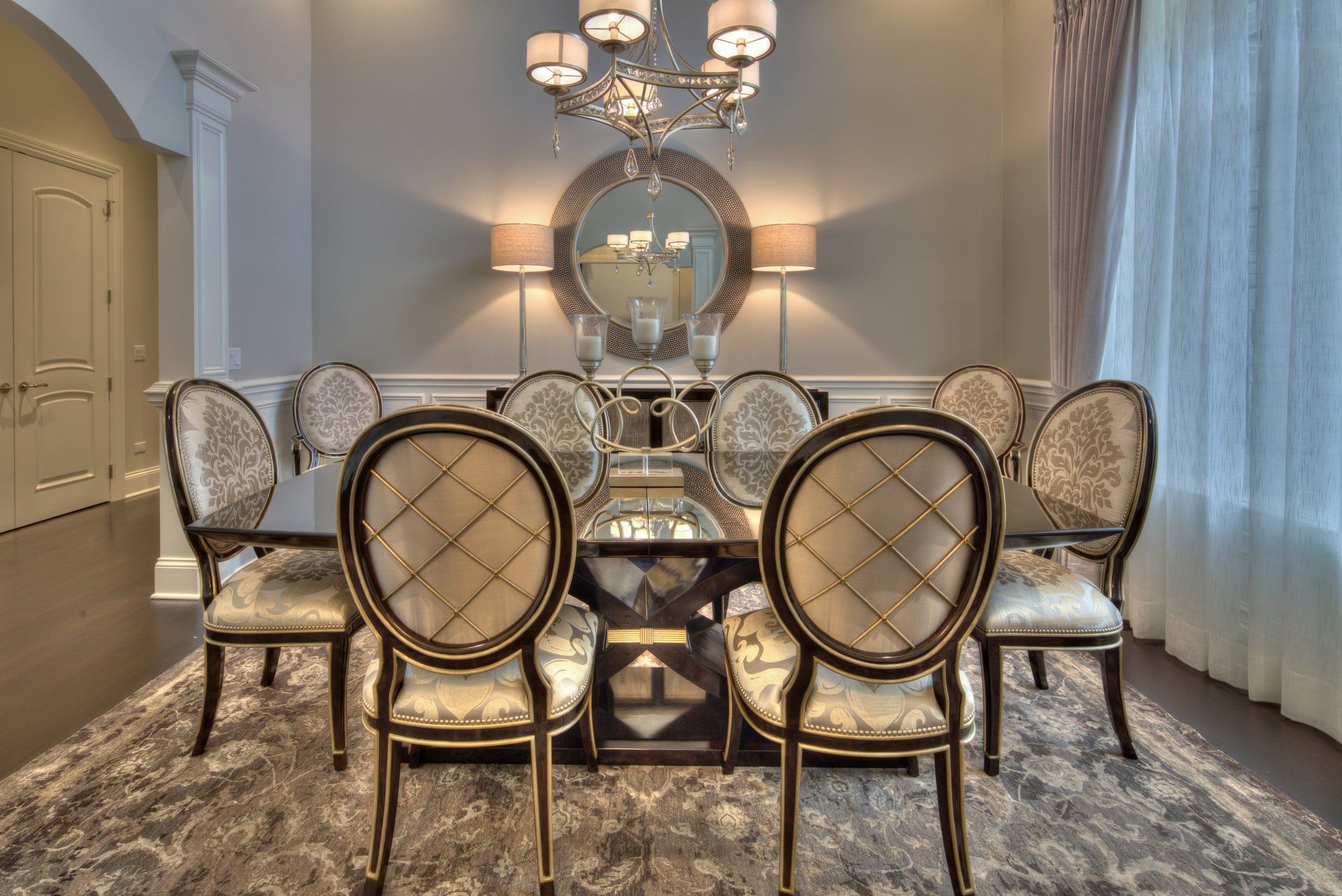 A dining room with a table and chairs and a chandelier.