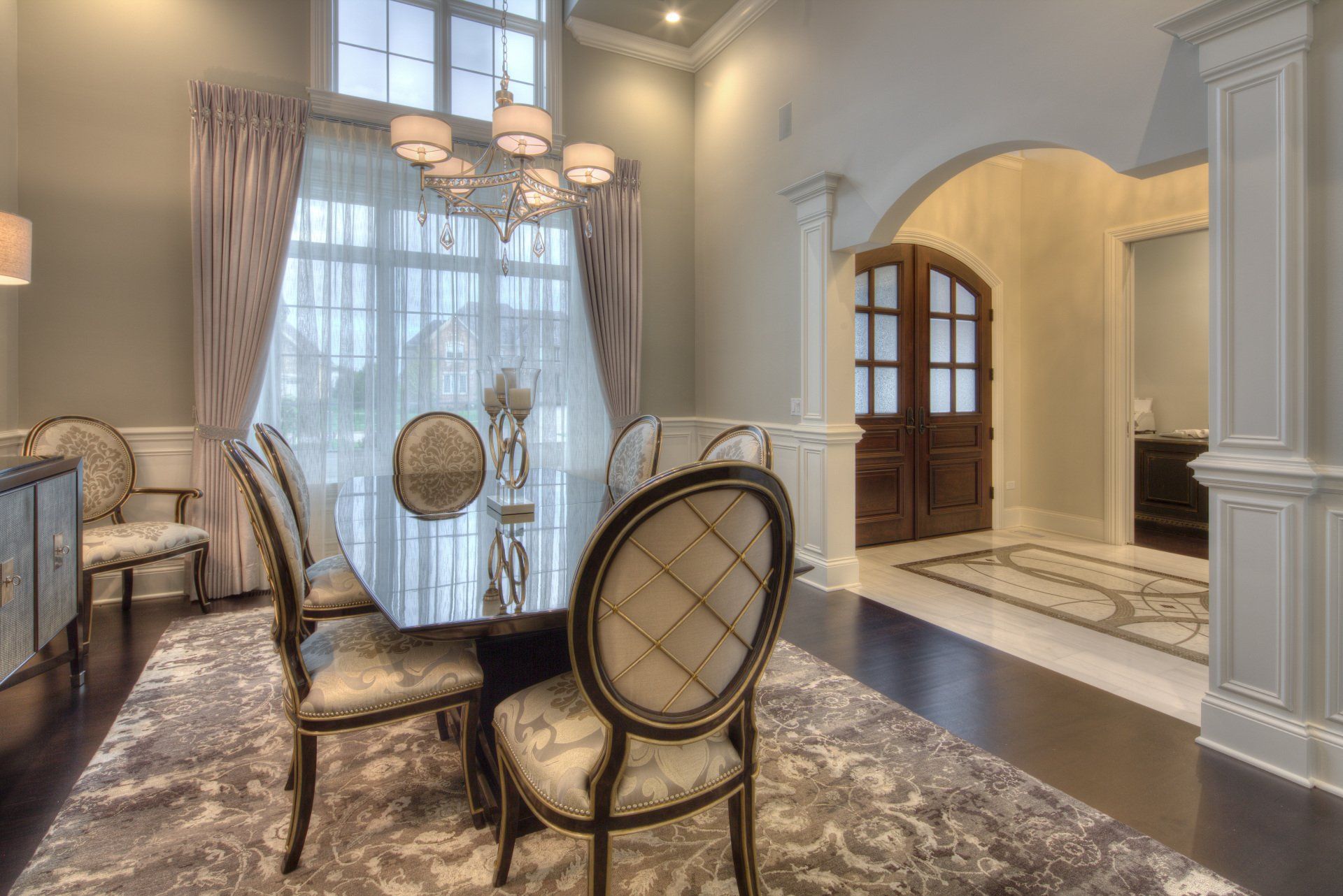 A dining room with a table and chairs and a chandelier.