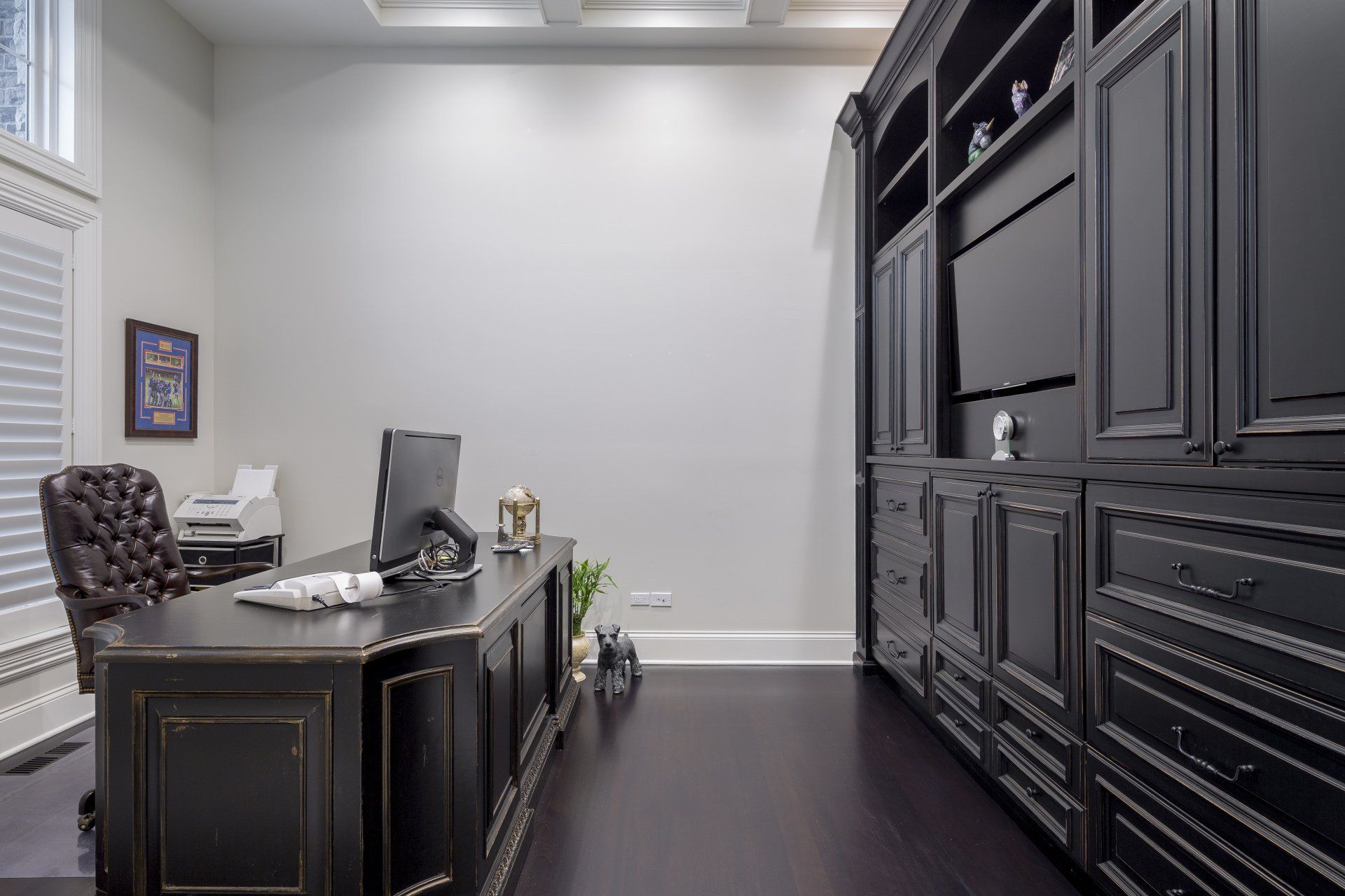 A home office with a desk , chair , computer and shelves.