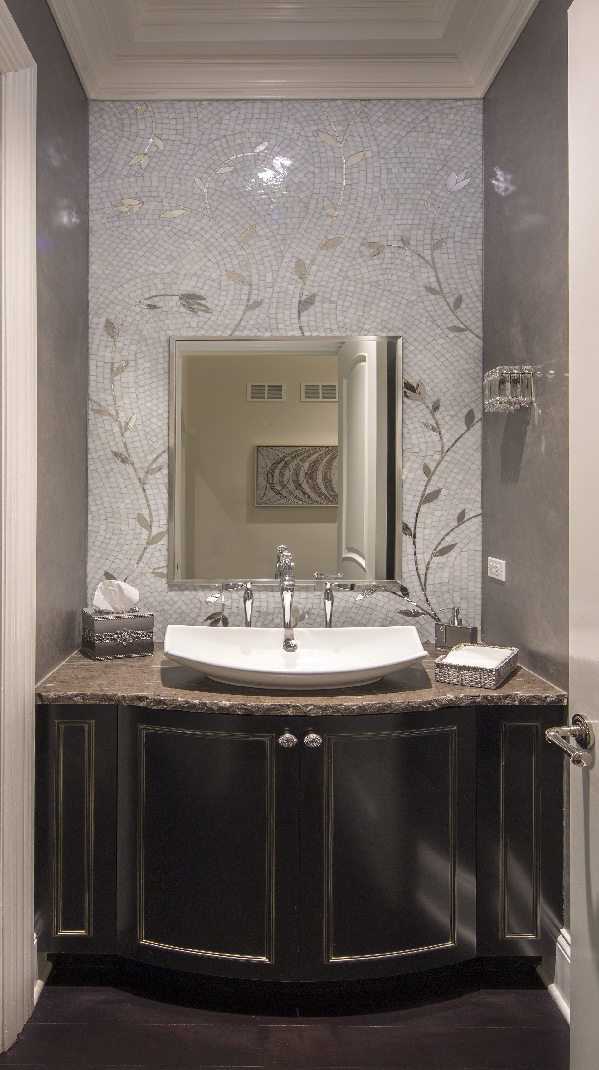 A bathroom with a sink , mirror and cabinets