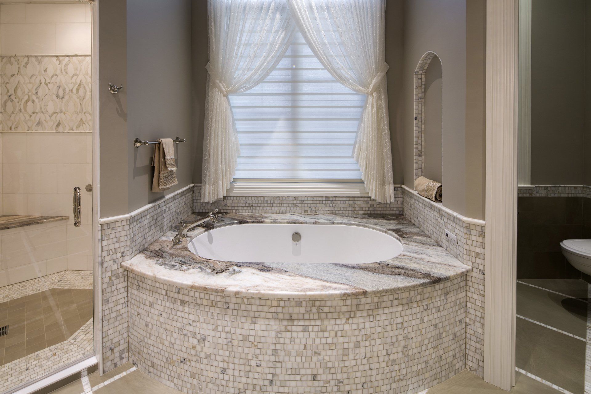 A bathroom with a jacuzzi tub and a window.