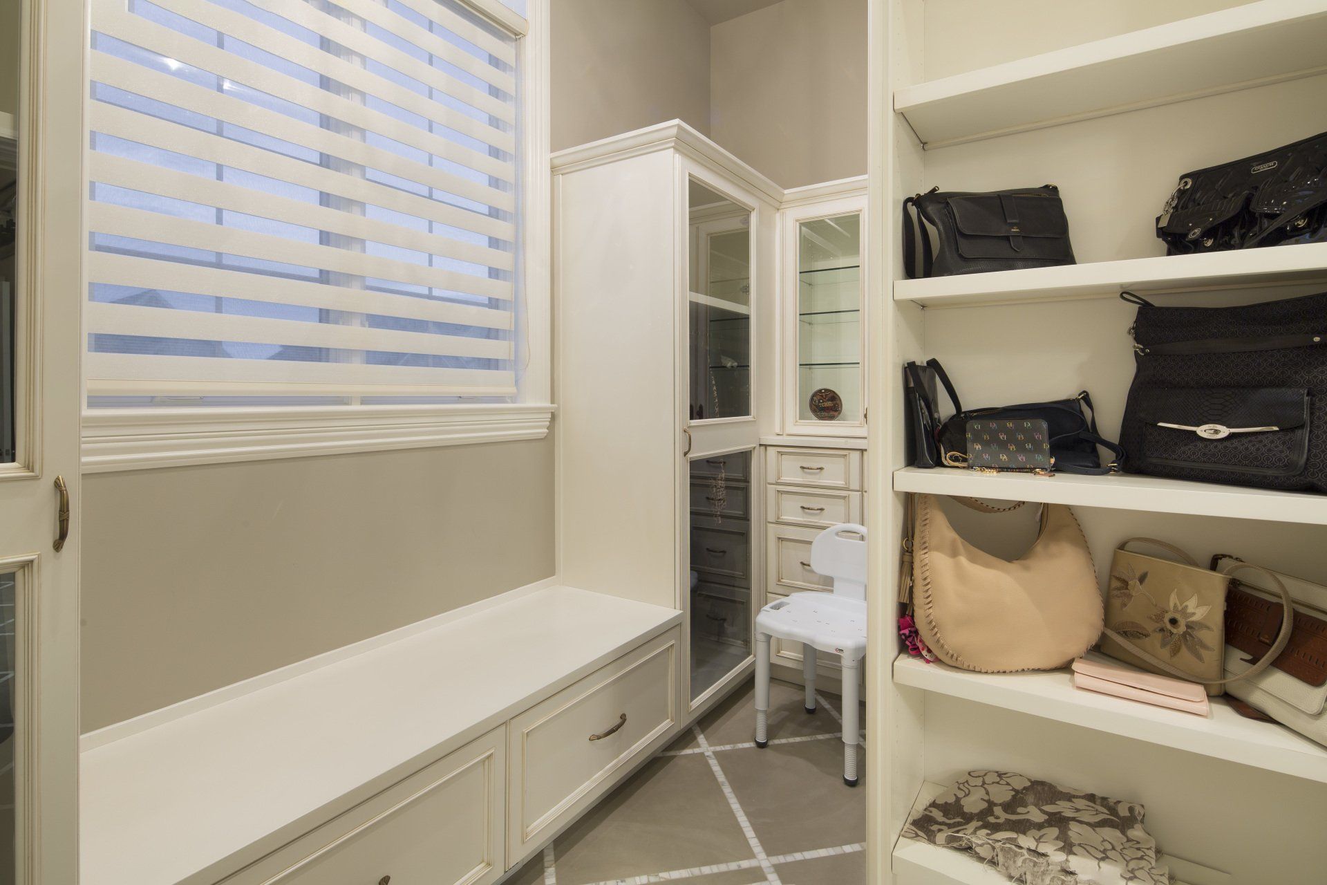 A walk in closet filled with lots of handbags and clothes.